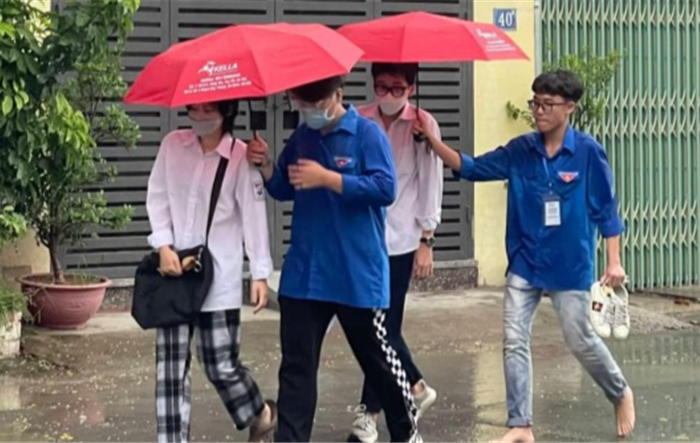 Tình nguyện viên Thủ đô “đầu trần” hứng mưa, nhường ô cho các thí sinh